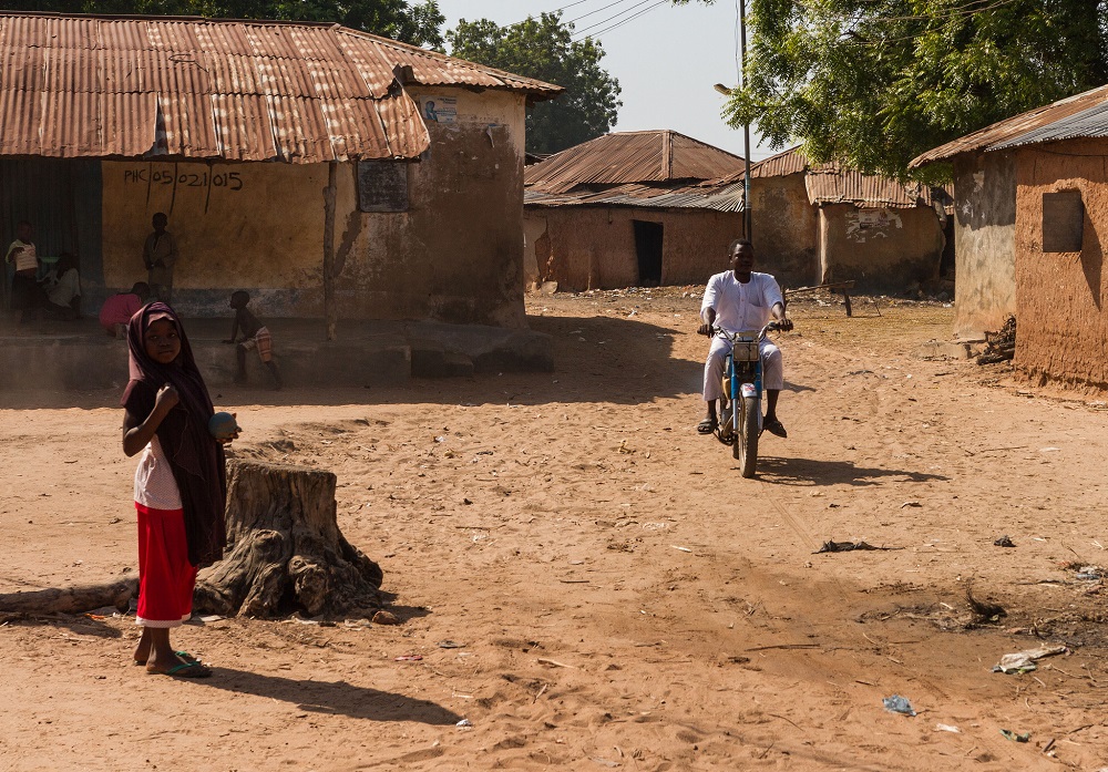 Un hombre conduce una motocicleta por la aldea de Bisanti, estado de Níger, Nigeria. Foto: Charlie Zajicek, 2018