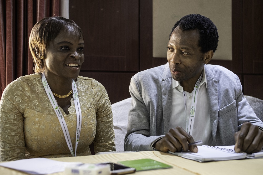 Los miembros de la Comunidad de Práctica de África Mini-Grids Rhoda Mando y Abbas AbdulRafiu comparan notas en el taller de 2018 en Abuja, Nigeria. Foto: Geraint Hill, 2018